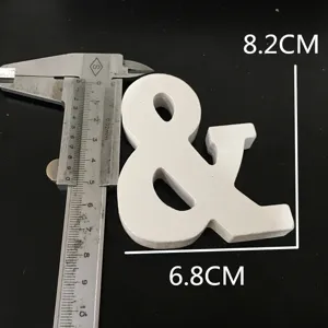 White wooden ampersand symbol detail shot showing precise dimensions with metal caliper.