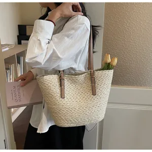Strohtasche mit braunen Leder schulterriemen für sommerliche Strand und Urlaubsreisen.