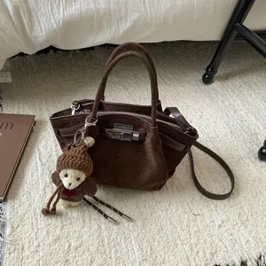 Retro brown suede handbag with metal lock and cute bear pendant, ideal for autumn and winter.