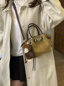 Korean vintage suede shoulder bag for women, stylish brown crossbody tote with cute bear pendant.