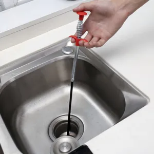 Rohrreiniger Werkzeug mit rotem Griff und flexibler Federgreifer für Haushaltsspüle und Abflussrohr.