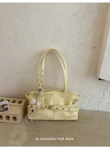 Detail view of the stylish yellow shoulder bag, featuring unique belt accents and casual commuter design.