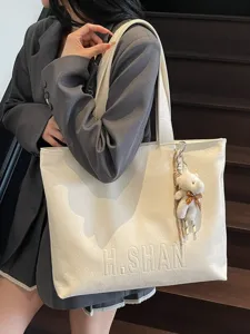 Spacious minimalist women white leather tote bag with embossed letters and cute bear pendant.