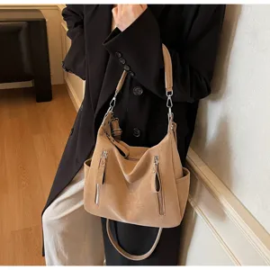 Detailed view of the large capacity beige slouchy hobo shoulder bag with front zipper pockets.
