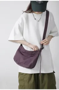 Λεπτομερής όψη της casual μωβ καμβά τσάντας χιαστί, η οποία φοριέται από το μοντέλο.
