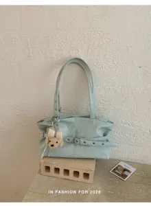 Detailed view of the stylish light green shoulder bag featuring a cute bear pendant charm.