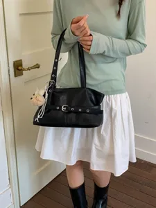 Black leather shoulder bag for women, trendy underarm purse with eyelet belt and cute charm.