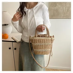Vue détaillée du sac seau en paille tissée vintage avec texture naturelle et fermeture à cordon.