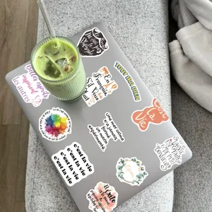Detailed view of French motivational quote stickers displayed on a laptop, waterproof vinyl decals.
