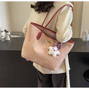 ευρύχωρη ροζ τσάντα tote με κόκκινο τελείωμα και χνουδωτό μενταγιόν αστέρι για την καθημερινότητα.