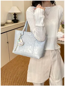 Detail view of the light blue PU leather tote bag with cute rabbit charm, perfect for daily commuting.