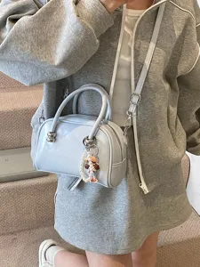 Trendy light blue Boston pillow bag for women, chic shoulder crossbody handbag with pearl charm.