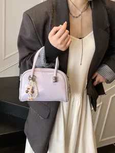 Trendy purple Boston handbag for women, stylish summer shoulder crossbody pillow bag with charm.