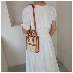 Detailed view of the chic woven crossbody bag worn with a white summer dress in a minimalist room.