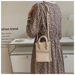 Detail view of woven crossbody phone bag with leather handle, chic daily summer fashion.
