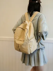 Vue détaillée du grand sac à dos en toile beige, mettant en valeur un style quotidien.