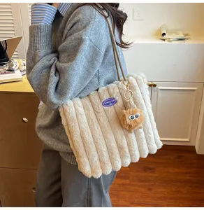 Fluffy plush tote bag detail showing soft vertical stripes and cute monster keychain charm.