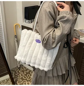 White fuzzy plush tote bag detailed view showing soft faux fur texture and comfortable shoulder strap.