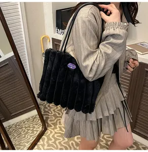Black plush shoulder bag for women, fluffy winter tote bag with pleated design and top handles.