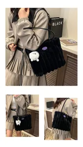 Black plush tote bag detail shot, soft furry shoulder bag with cute pom-pom pendant.