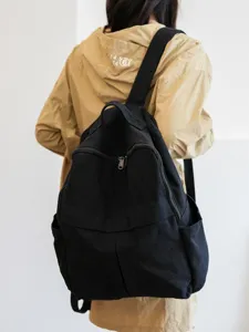 Sac a dos noir minimaliste en toile, grande capacite et multiples poches pour le voyage.