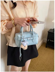Dettaglio borsa a mano bowling azzurra, elegante borsa Boston in pelle con ciondolo.