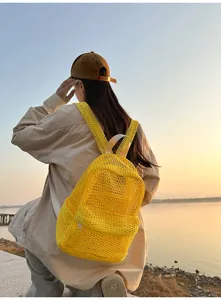 Yellow mesh backpack detail view, breathable lightweight summer travel bag in bright color.