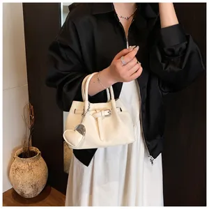 Stylish white woven bucket handbag for women, chic crossbody shoulder bag with heart charm.