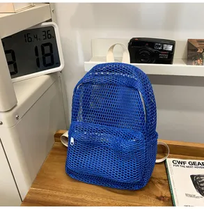 Detailed view of a trendy blue mesh backpack showcased in a modern lifestyle room.