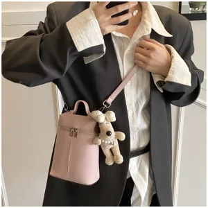 Pink mini bucket bag detail view with cute puppy plush charm, shoulder crossbody style.