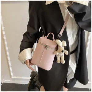 Pink leather crossbody mini bag detail with cute puppy pendant and elegant shoulder strap.