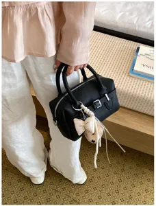 Primo piano della borsa a mano da bowling in pelle nera con dettaglio ciondolo.