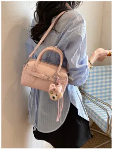 Borsa bowling Boston in pelle rosa con ciondolo ad orsetto indossata dalla modella.