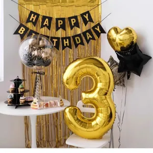 Birthday party decoration set with gold fringe curtain, letter banner and foil balloons.