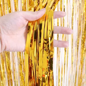 Gold tinsel fringe curtain detail close up, shiny metallic backdrop decoration for party.