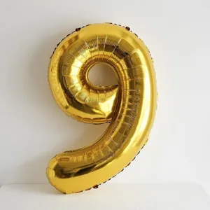 Close-up of a shiny metallic gold number 9 foil balloon for birthday party decor details.