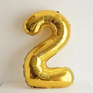 Gold number 2 foil balloon detail shot, brilliant birthday party decoration closeup display.