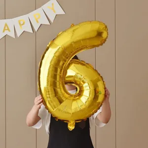 Close-up detail of a shiny gold number 6 foil balloon used for child birthday party decoration.