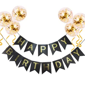 Closeup of black gold happy birthday banner and confetti balloons party decoration details.