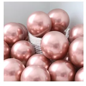 Primo piano di palloncini sferici metallici oro rosa lucidi per feste di compleanno.