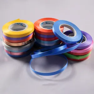 Rotoli di nastro colorato per confezioni regalo, cordino per palloncini e decorazioni.