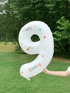 Outdoor detail scene of a 40-inch white number 9 foil balloon with happy birthday prints.