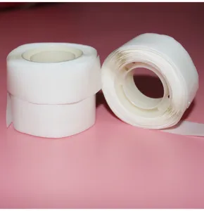Close up detail of transparent double sided balloon glue dot rolls for craft and party decor.