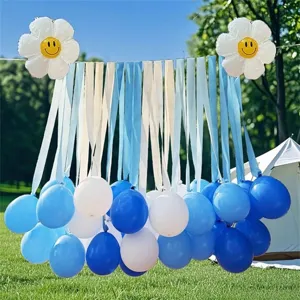 Outdoor party decor detail showing blue and white balloons with ribbons and daisy balloons.