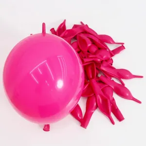 Detailed shot of thick hot pink linking balloons and uninflated latex balloons for party decor.