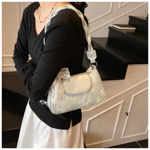 Vue détaillée du sac porté épaule avec imprimé nuage, bandoulière tressée et nœud en dentelle.