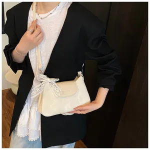 Vue détaillée du sac à épaule crème élégant avec nœud en dentelle délicat et design unique.