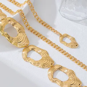 Close-up detail of the stylish gold metal waist chain featuring unique wave-textured geometric discs.