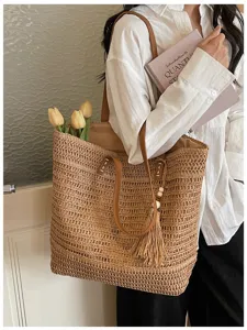 Vista dettagliata della borsa tote in paglia casual con tracolla e ciondolo con nappina elegante.