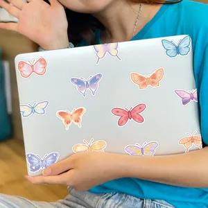 Detailed view of colorful cartoon butterfly stickers decorating a laptop surface, cute design.